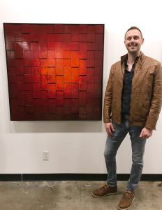 Andy Hahn artist standing with his modern abastract painting